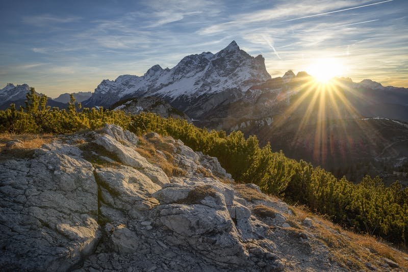 Alpinista na vrhu planinskog vrha sa zastavom