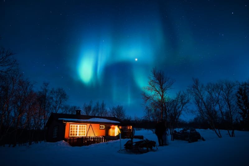 Mala koliba pod svjetlošću aurora borealis u Norveškoj